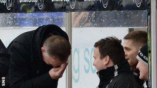 Inverness boss John Hughes nurses a cut to his head after banging it off the dug-out