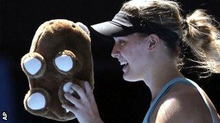 Eugenie Bouchard walks off the court with a toy wombat thrown to her by a supporter