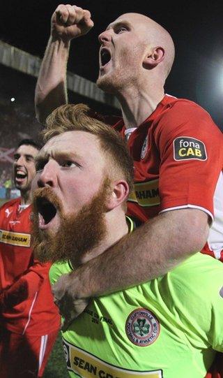 Reds keeper Conor Devlin, who saved two penalties in the shoot-out, enjoys the victory with Ryan Catney