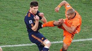 Nigel de Jong puts in a high tackle on Xabi Alonso