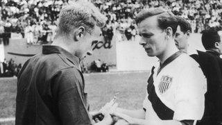 England's Billy Wright and USA's Ed McIlvenny exchange souvenirs before the match