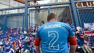 A fan pays tribute to Rangers great Sandy Jardine, who died on Thursday