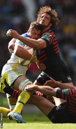 Damien Chouly of Clermont Auvergne is tackled by Jacques Burger