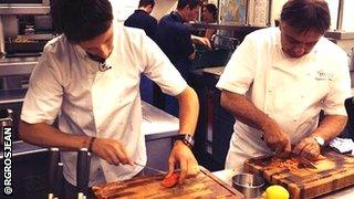 Lotus driver Romain Grosjean is taught some new culinary skills by Raymond Blanc