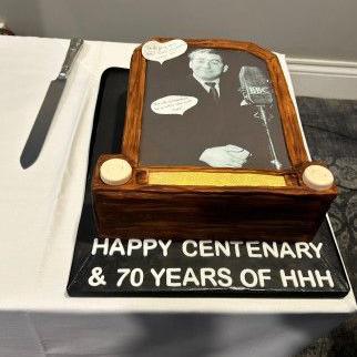 A birthday cake with a black and white image of Mr Hancock on it