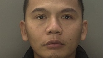 Le has close cropped hair in his police mugshot. He is wearing a dark top.