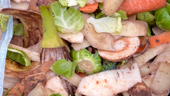 A pile of vegetable peelings including turnips, carrots and Brussels sprouts. 