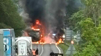 Huge orange flames takeover the road on a motorway