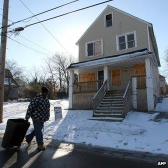 A man walks past a boarded up building in the Mount Pleasant section of Cleveland, Ohio, in January 2008