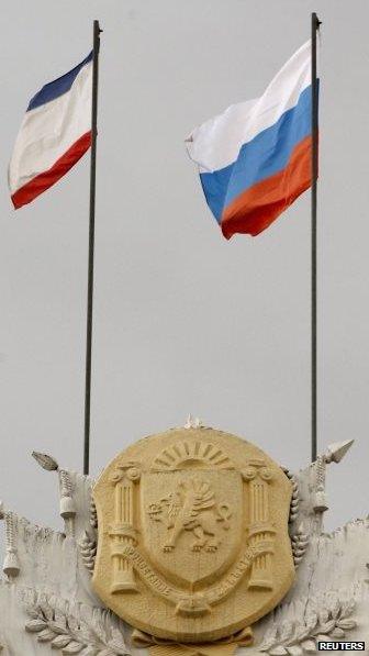 Russia's flag (R) and Crimea's regional flag on a building in Simferopol