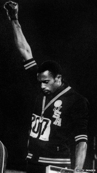 Tommie Smith raises his right arm in protest during the 1968 Olympics.