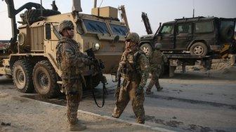 US and British soldiers chat at the site of a suicide attack in Kabul, Afghanistan