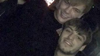 A blurry photo showing a smiling Lee Harrison, who has brown hair, posing with a taller man, Niall Barry, who has lighter blonde hair