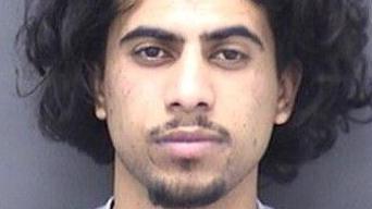 Custody photo of Mohammed Abdullah who has thick black hair and a goatee beard and moustache