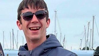 Hayden Davies smiles at the camera wearing sunglasses wearing normal civilian clothes in a photo taken before he was in Russian captivity.