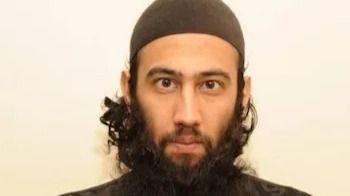 A close up photo of Zahid Iqbal shows him wearing a brown cap. He has a long beard and is staring at the camera