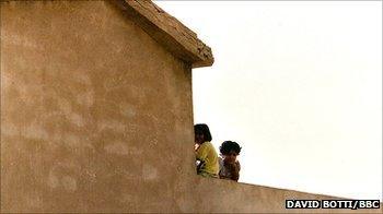 Young Iraqi girls sit on a roof