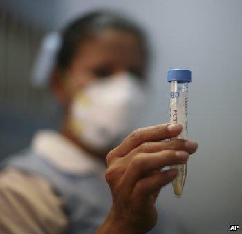 Nurse with sample from patient with swine flu