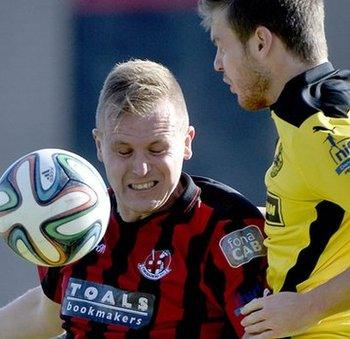 Crues striker Jordan Owens beats Cliftonville's Jaimie McGovern to the ball at Seaview