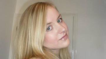 Abbigail Smith has long blonde hair. She is smiling and tilting her head towards one of her shoulders.