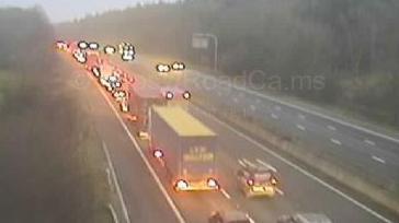 A motorway camera image shows lorries and cars queueing on the M4.