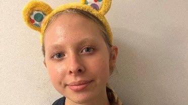 A portrait photo of Bea wearing a pair of Pudsey Bear ears.