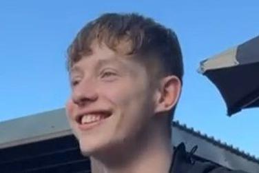 A young man smiling and looking obliquely to the camera