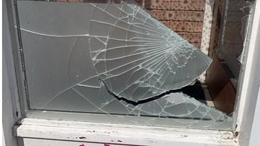 Image shows the damage to a mosque window which has been smashed. Some of the glass has broken away from the window and the glass that remains has been cracked.