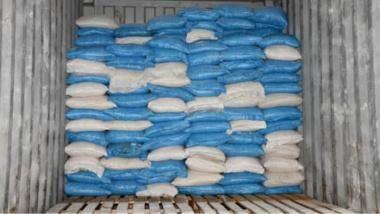 Bllue and white clingwrapped bags of cocaine in the bottom of a large trailer. 