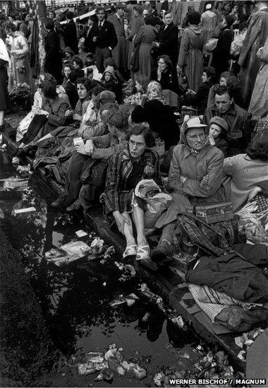 People wait on the pavement for the ceremony to begin