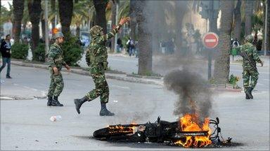 Tunisian troops and burning motorcycle, Tunis, 14 January 2011