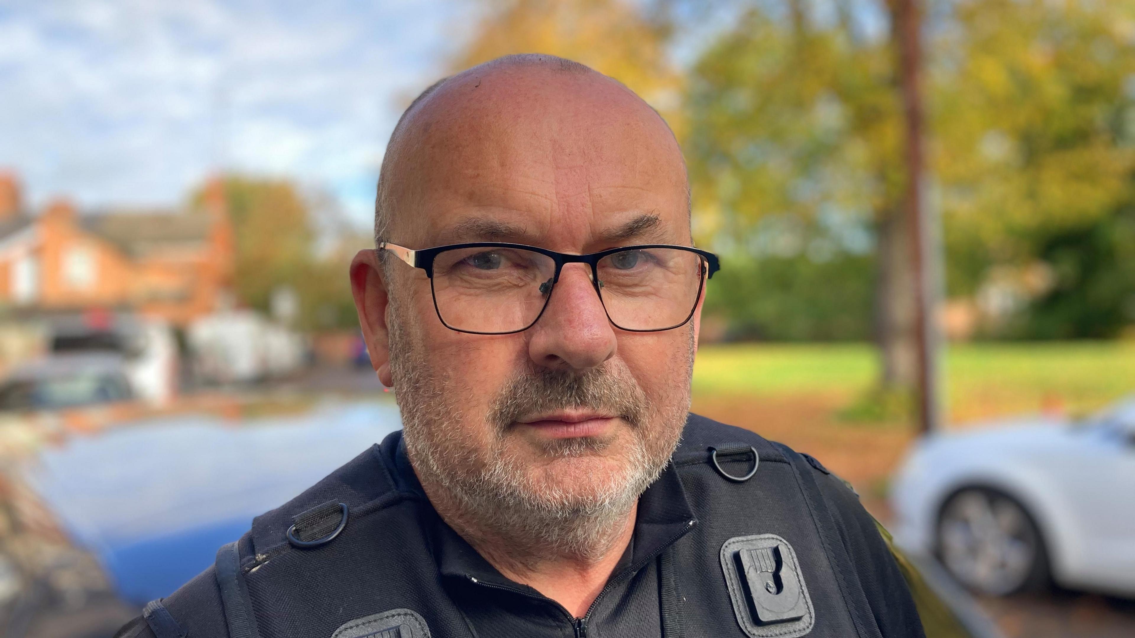 Paul Mitchinson wearing a black top wearing glasses and looking straight at the camera