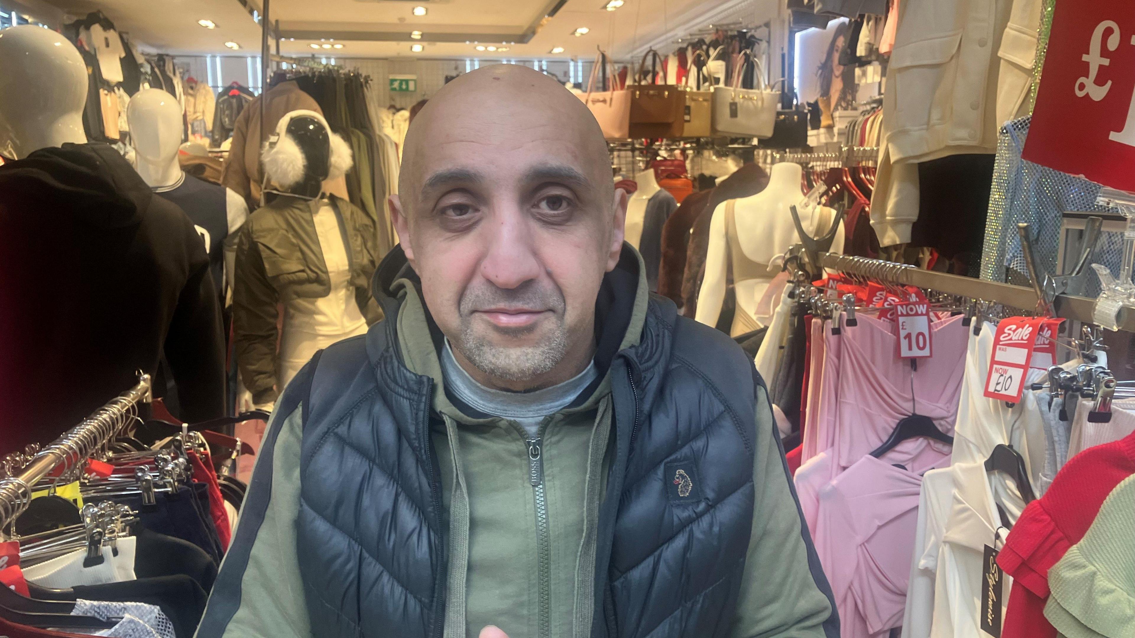 Photograph of shopkeeper outside his store in the Arcade shopping centre in Ashton under Lyne