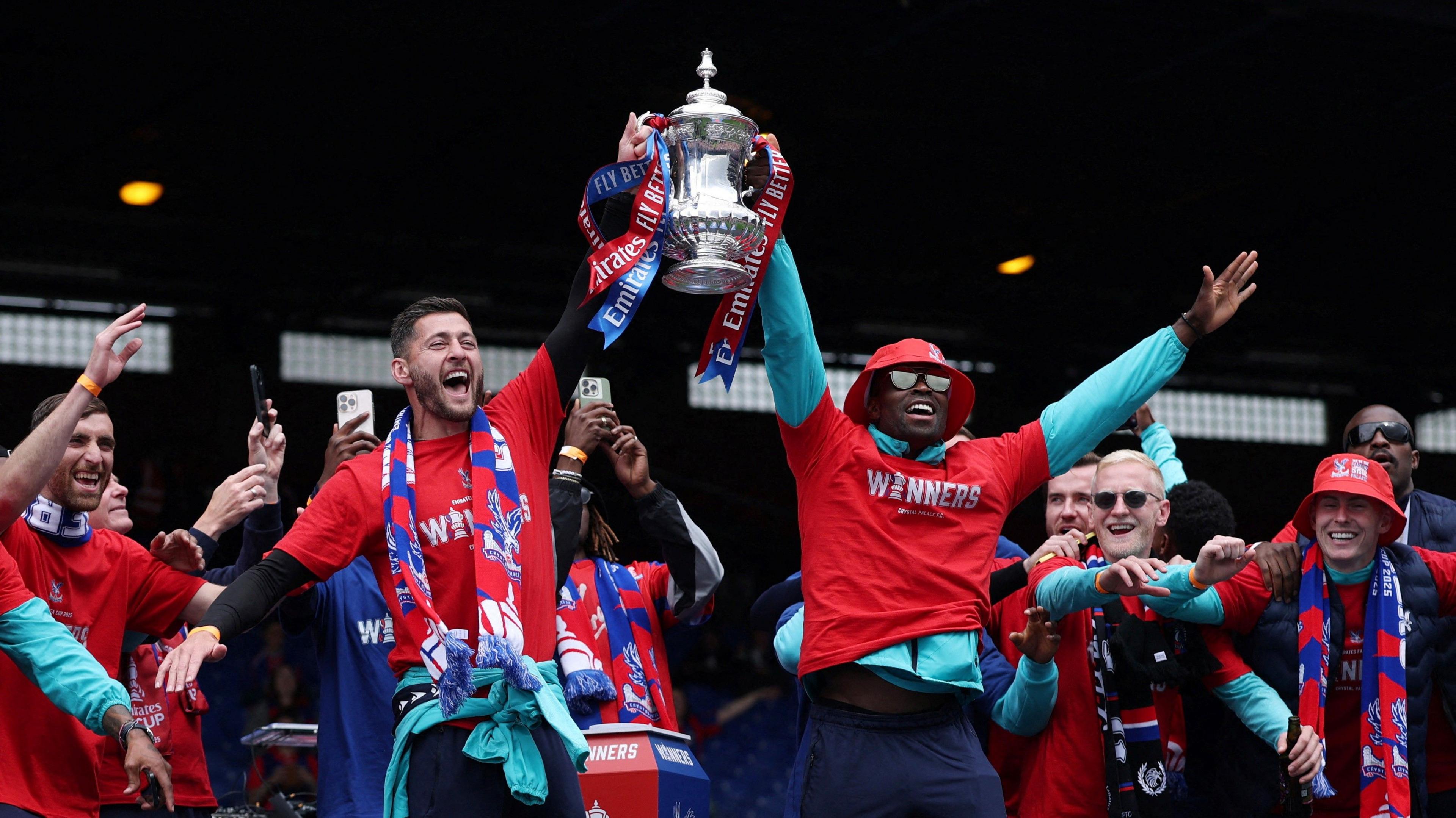 Crystal Palace's Joel Ward and Marc Guehi hold the trophy with teammates during the Victory celebrations after winning the FA Cup.