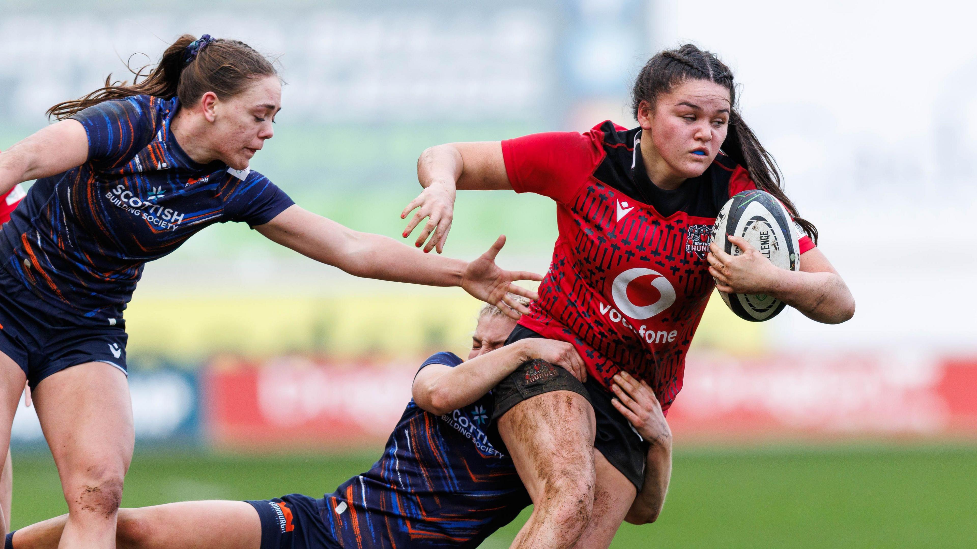 Jorja Aiono of Brython Thunder is tackled by Emily Love of Edinburgh
