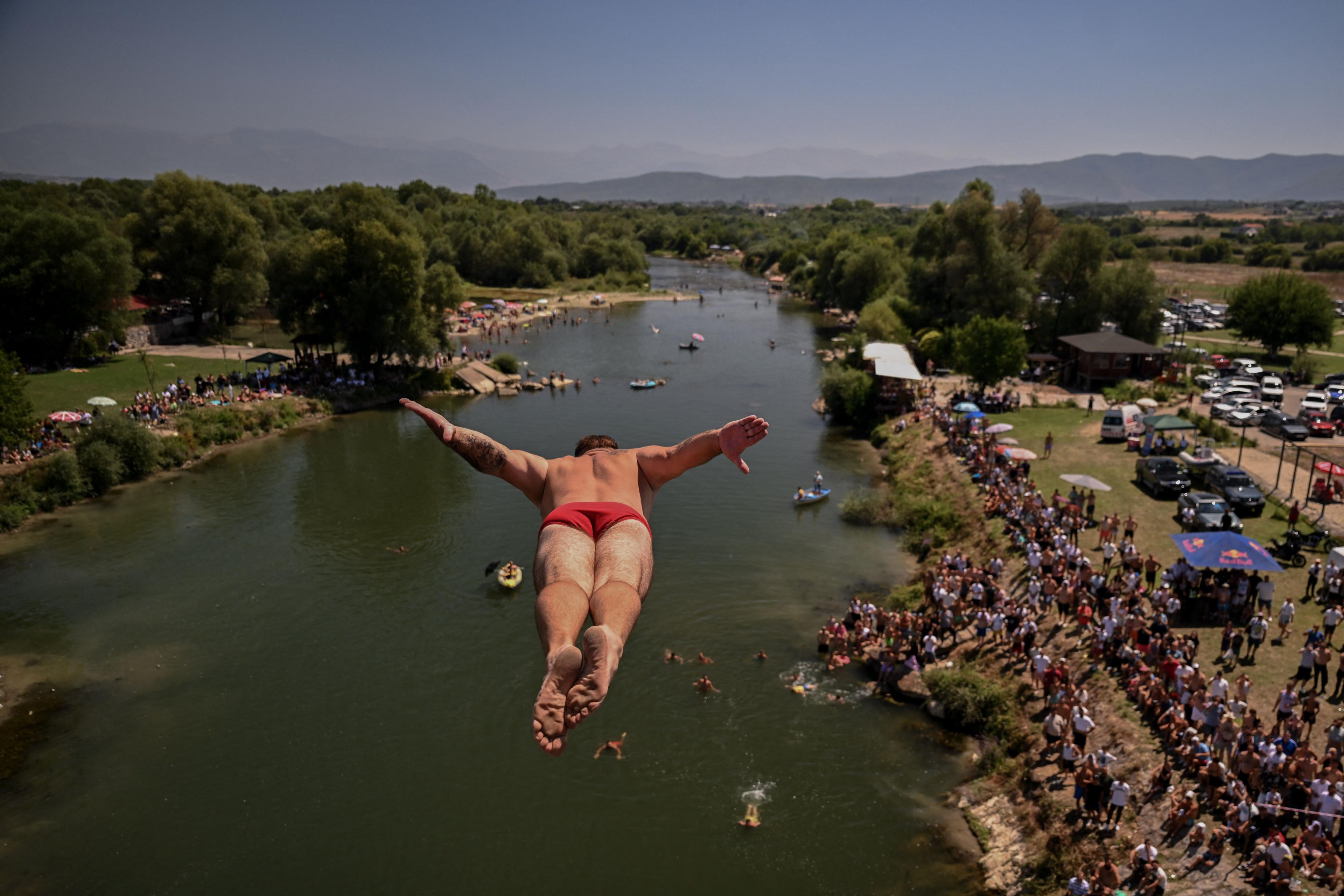 A diver jumps from a 22-metre-high bridge into the White Drin River during a traditional high diving competition near the town of Gjakova. Photo by Armend Nimani
