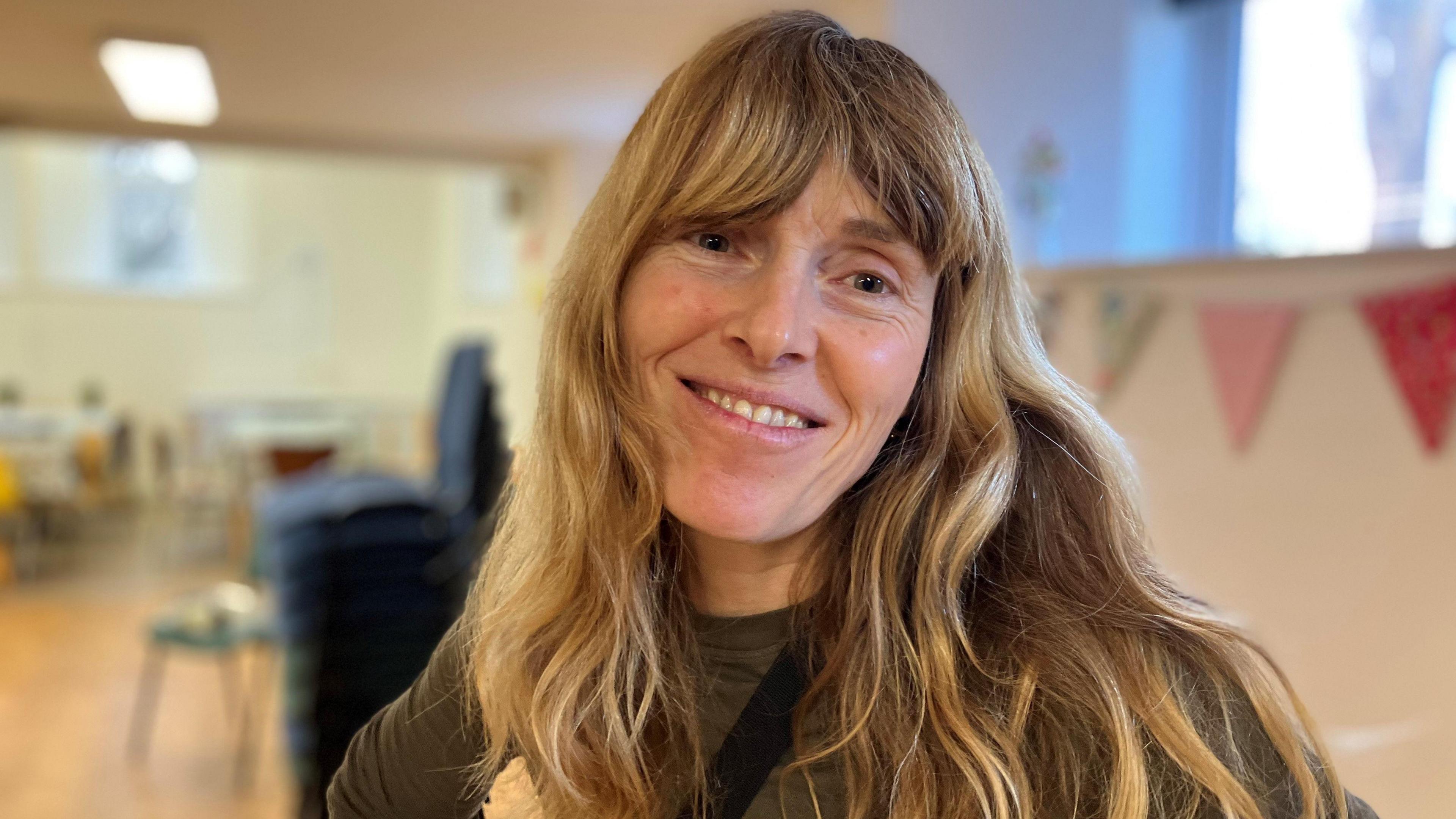 Woman with long hair smiling at the camera 