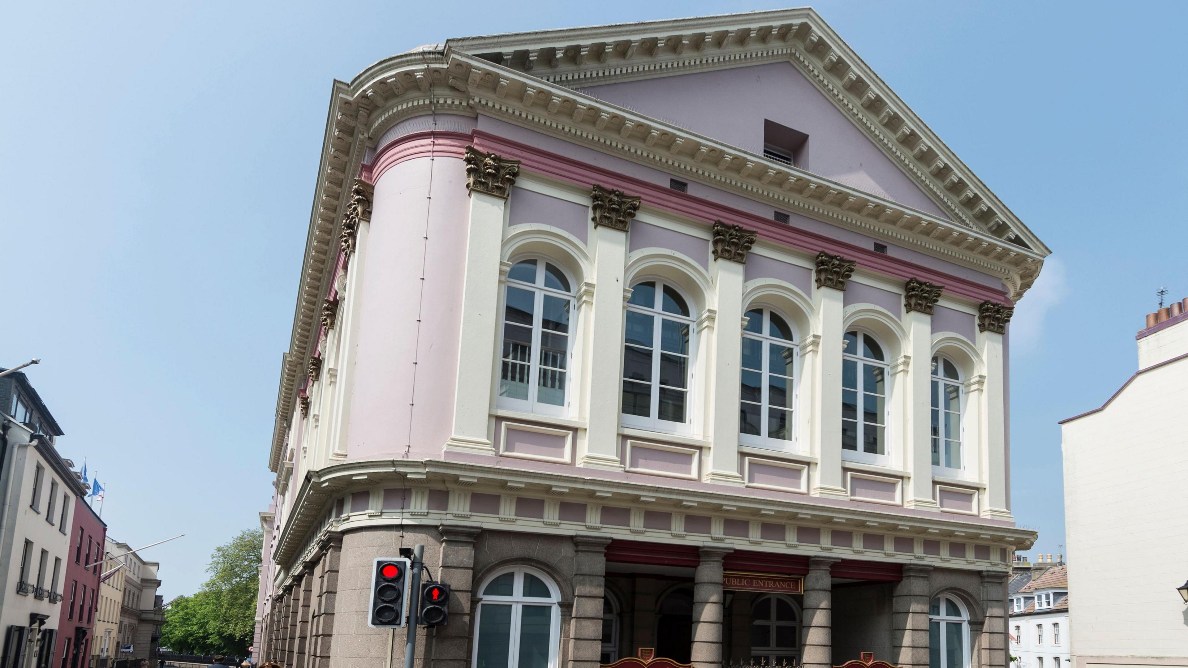 The States of Jersey (Chambre Des Etats) in St Helier in Jersey in the Channel Islands. The building is mostly pink and white.