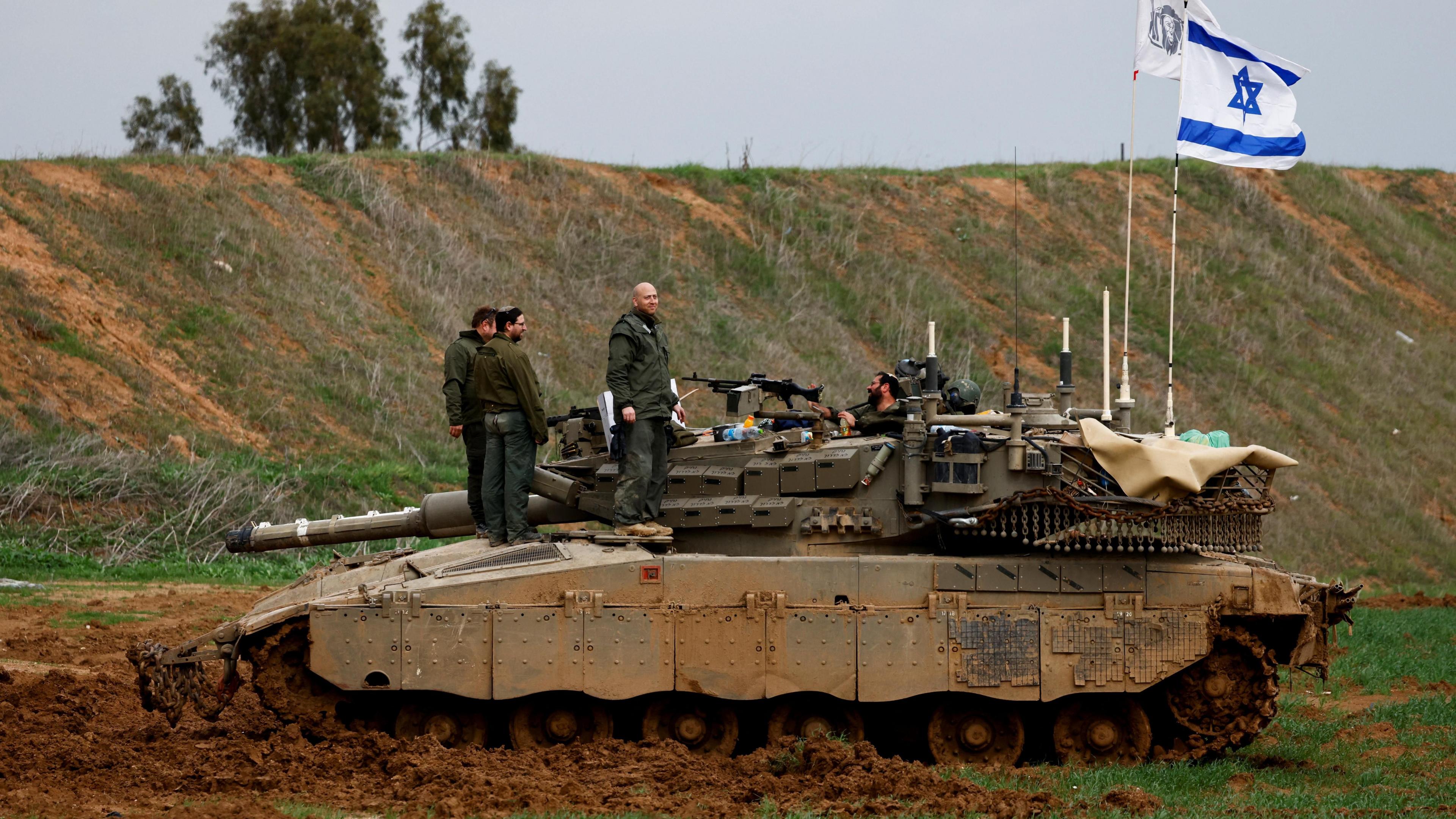 Israeli soldiers stand on top of a tank in southern Israel, near the Gaza perimeter fence (11 February 2025)