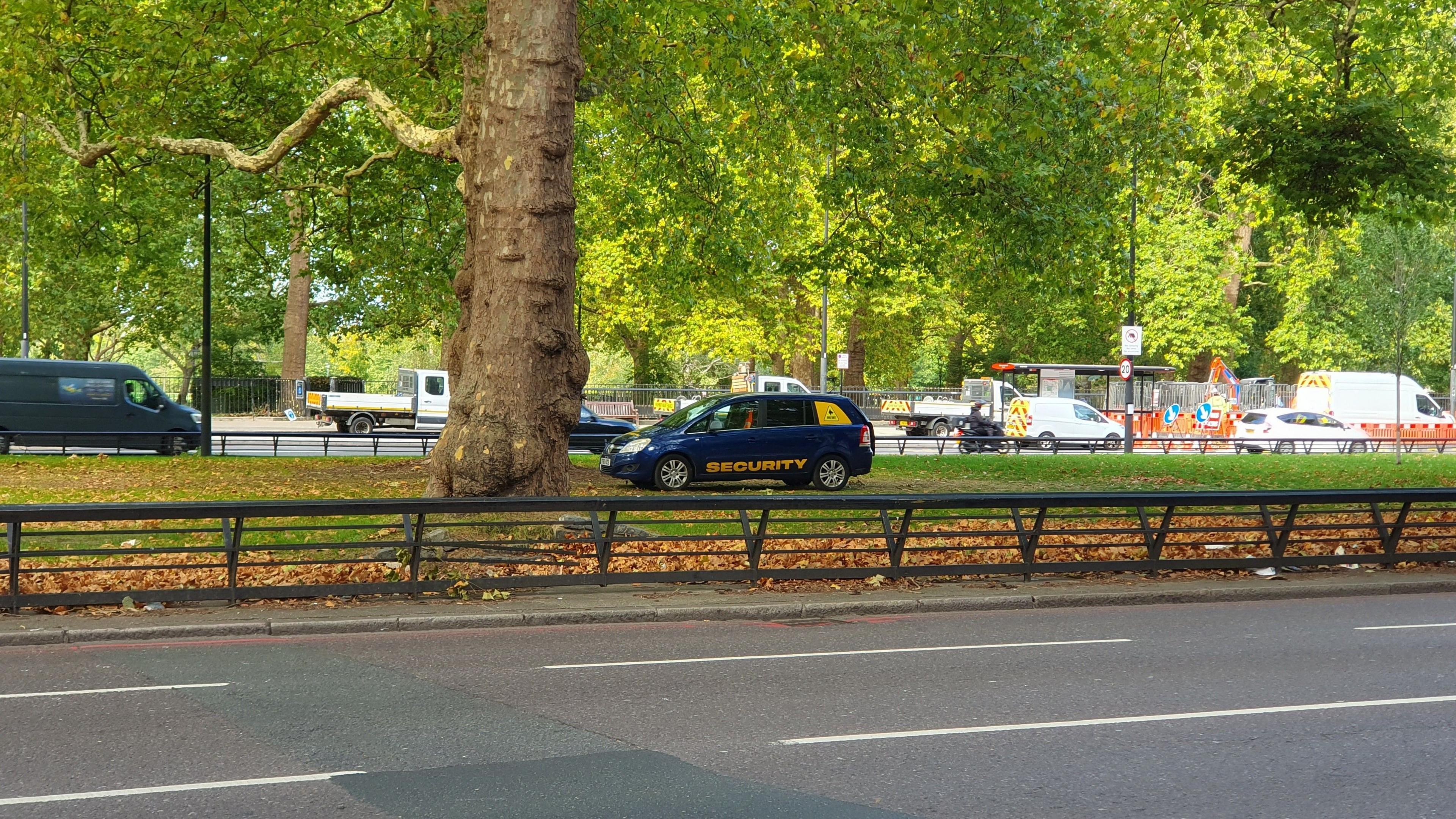 A black and yellow security car parked on a strip of grass at Park Lane.