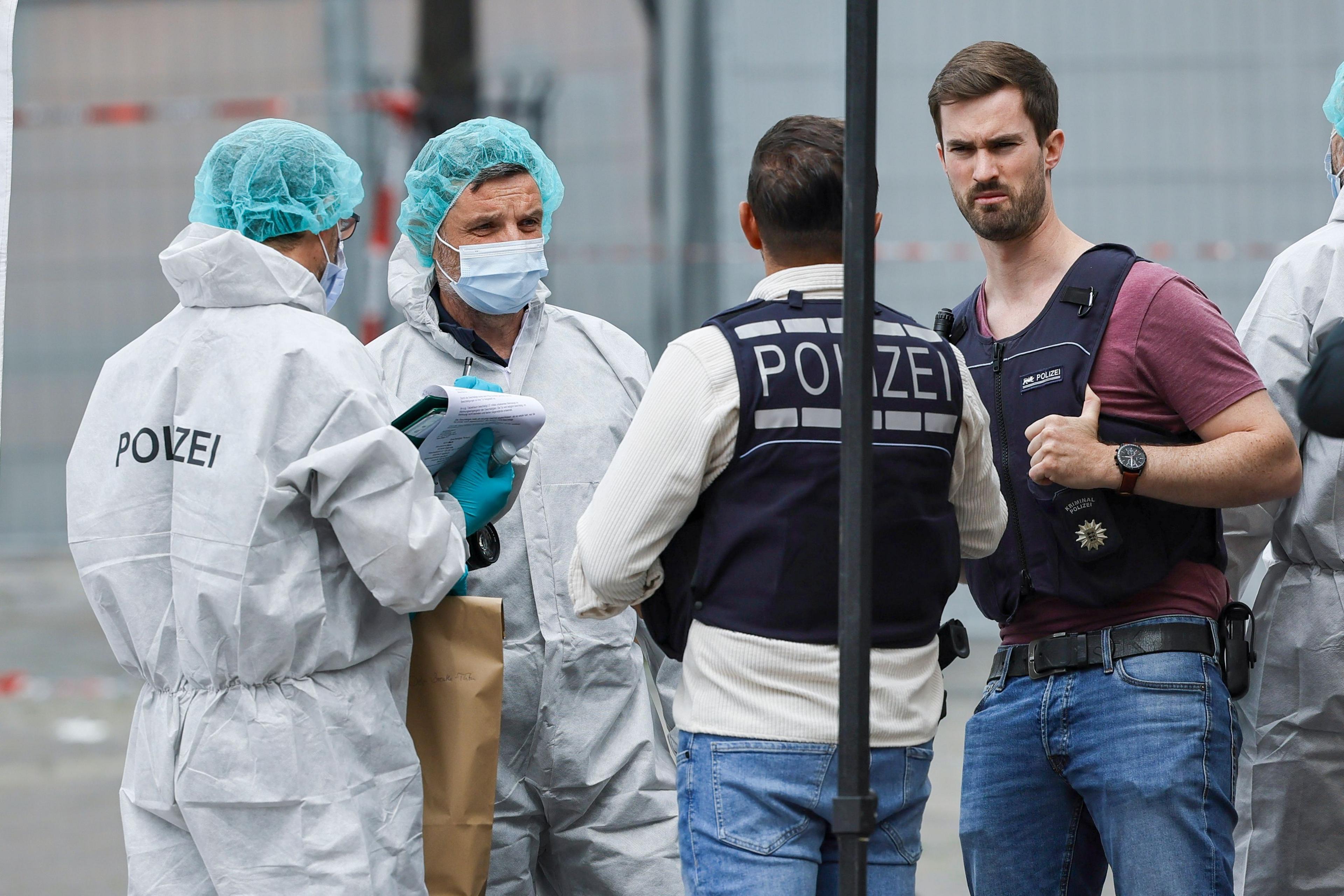 Four police officers in hazmat suits and bullet-proof vests