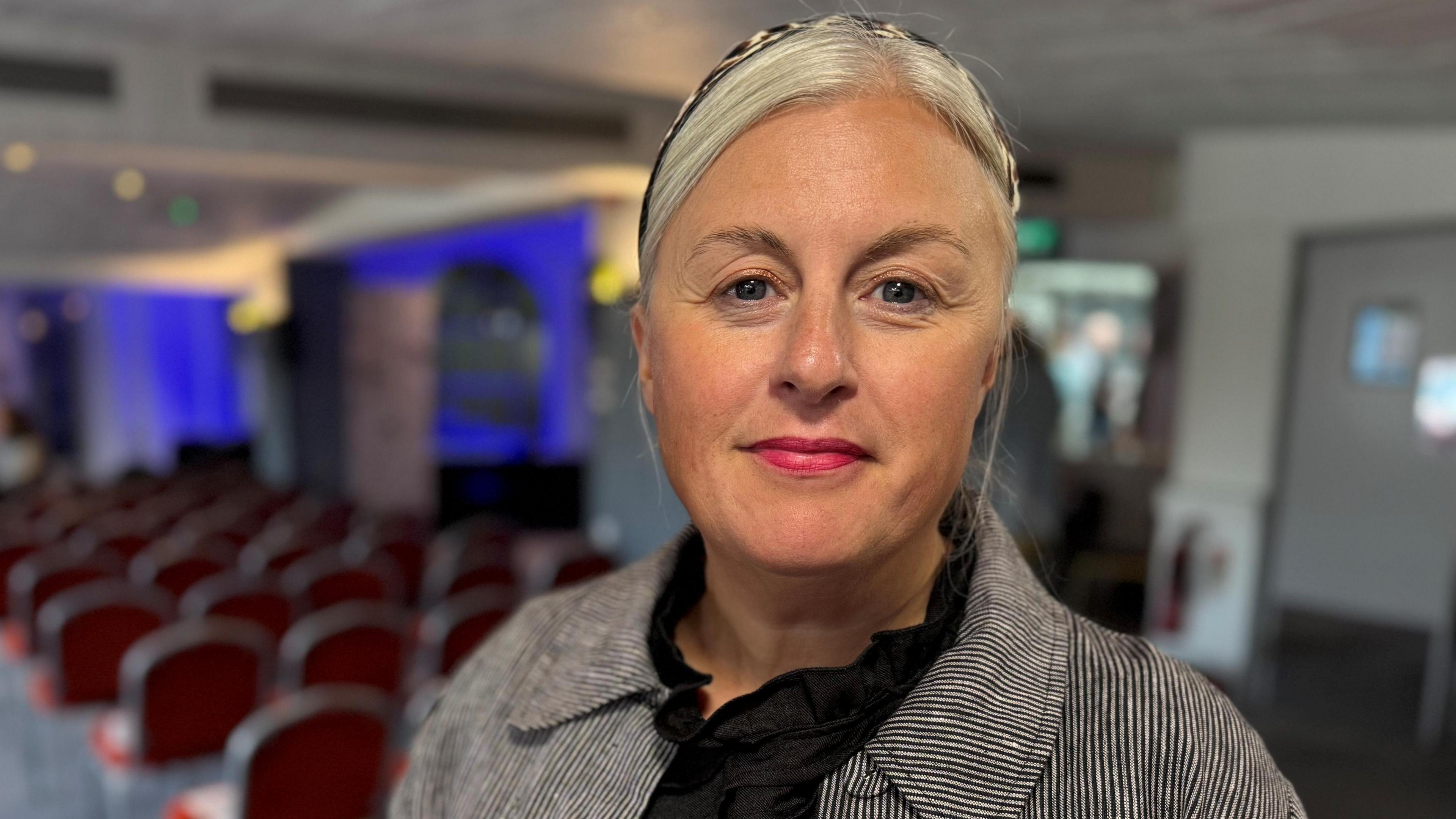 Head and shoulders of Michelle Welsh wearing a striped jacket and black top.