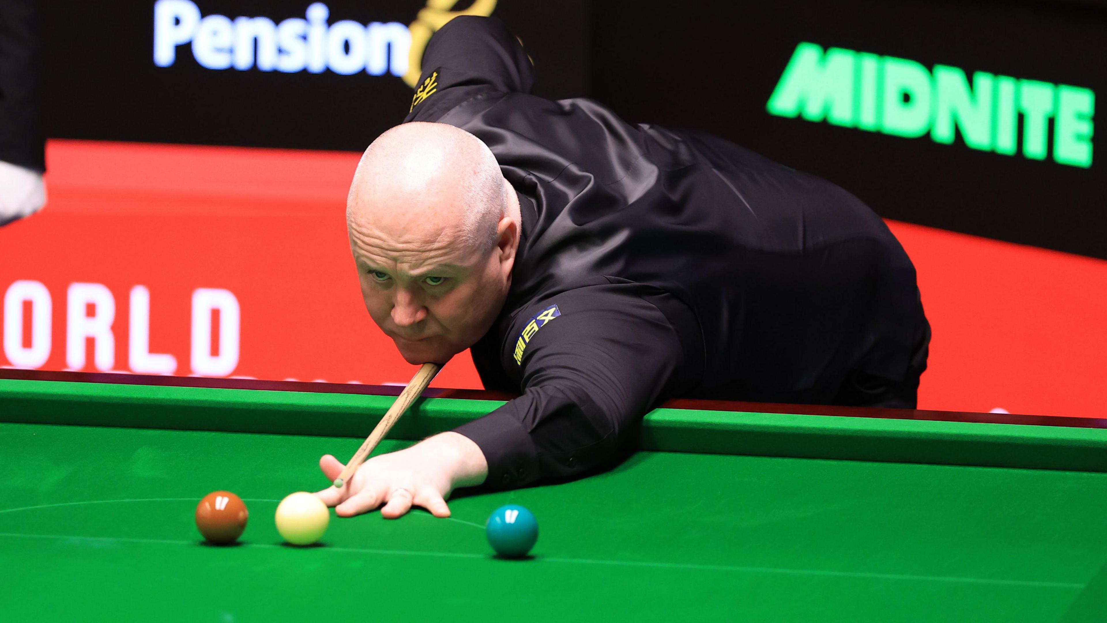 John Higgins plays a shot