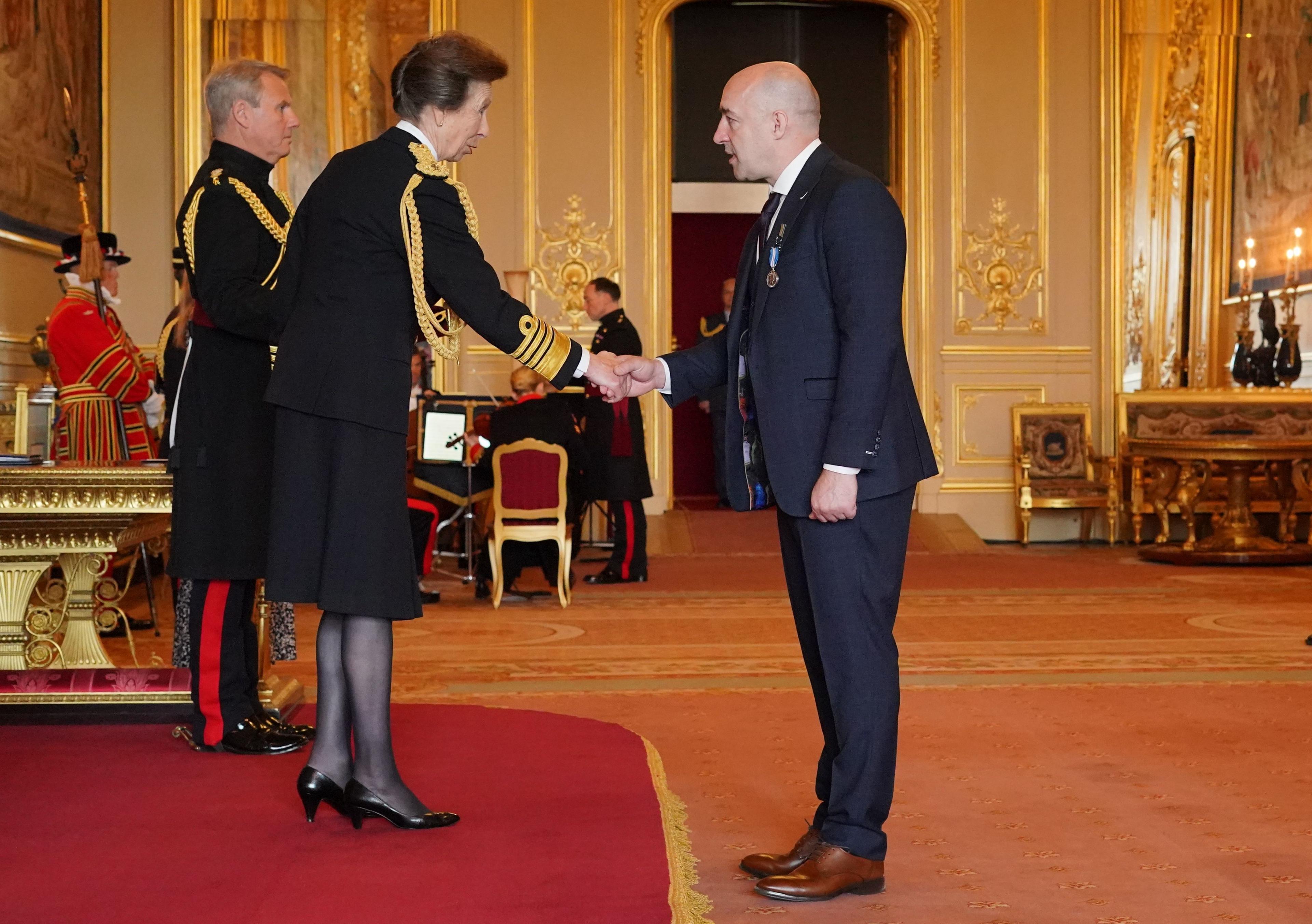 Steve Gallant shakes hands with the Princess Royal who is dressed in naval ceremonial uniform