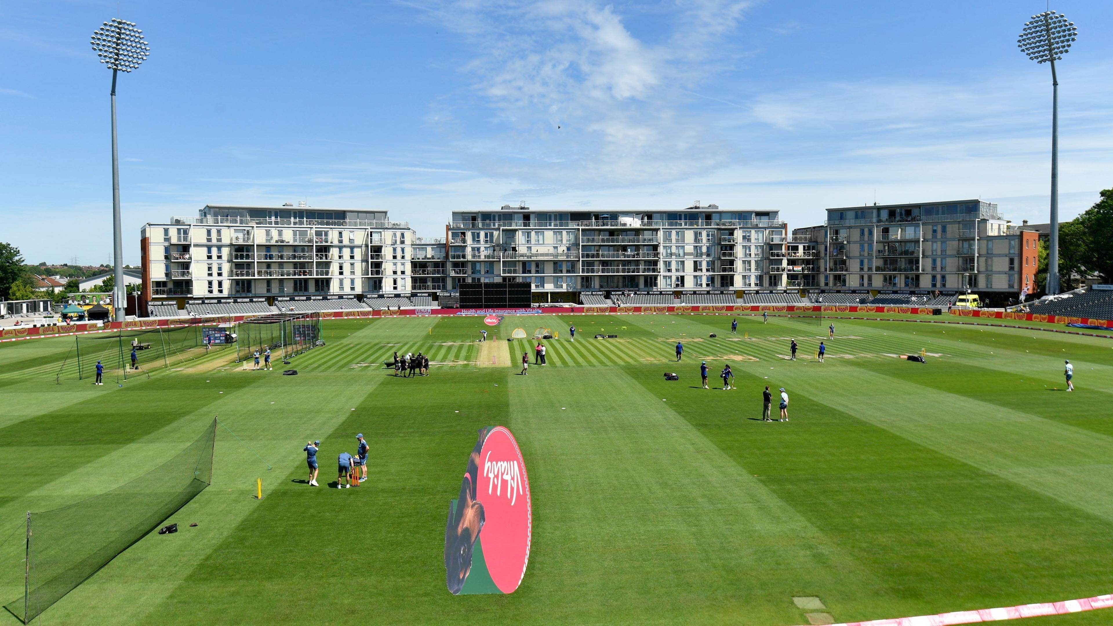 A wide-view shot of the Bristol County Ground cricket stadium, surrounded by blocks of the flats in the distance.