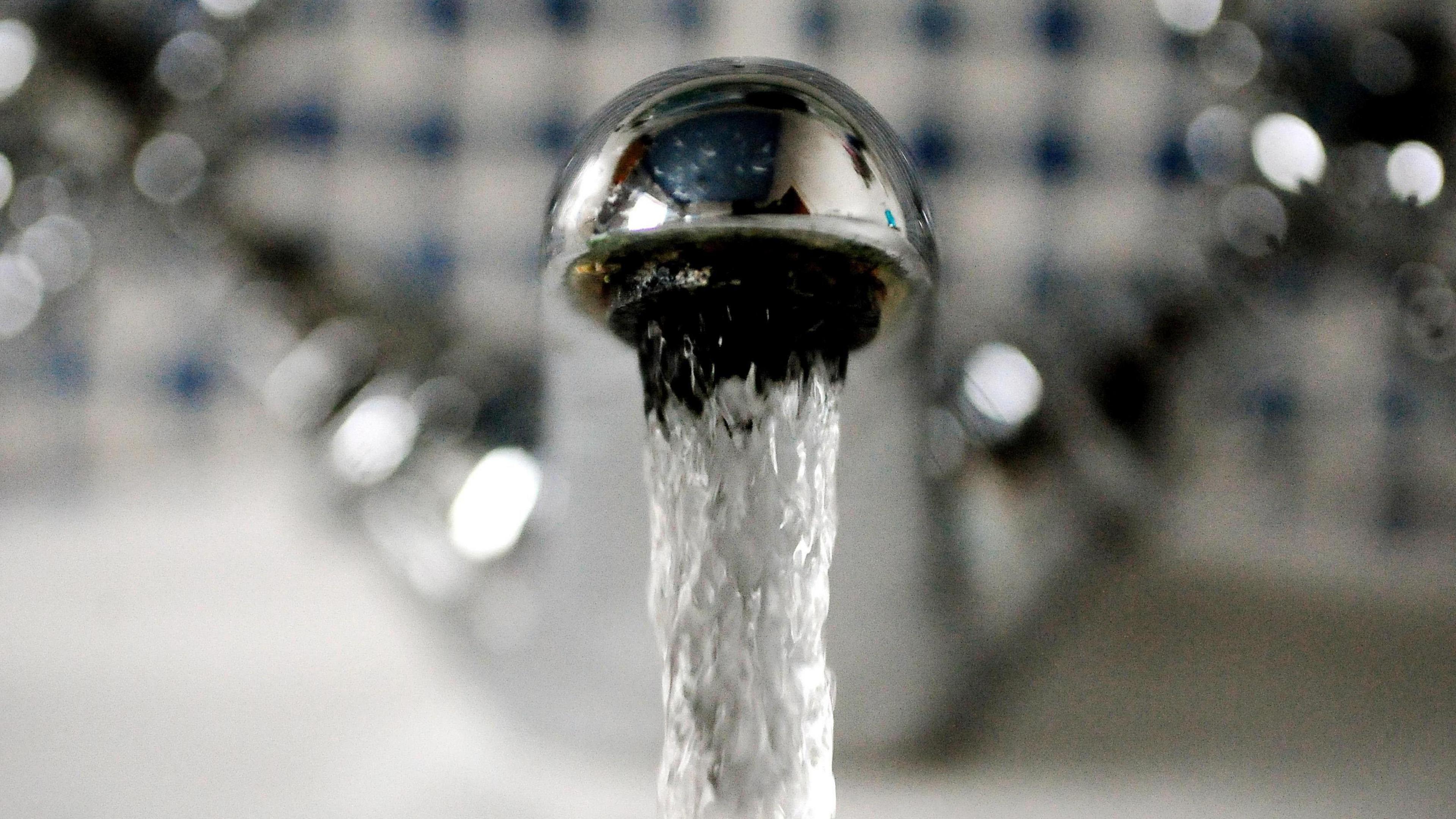 A close up picture of water running from a tap.