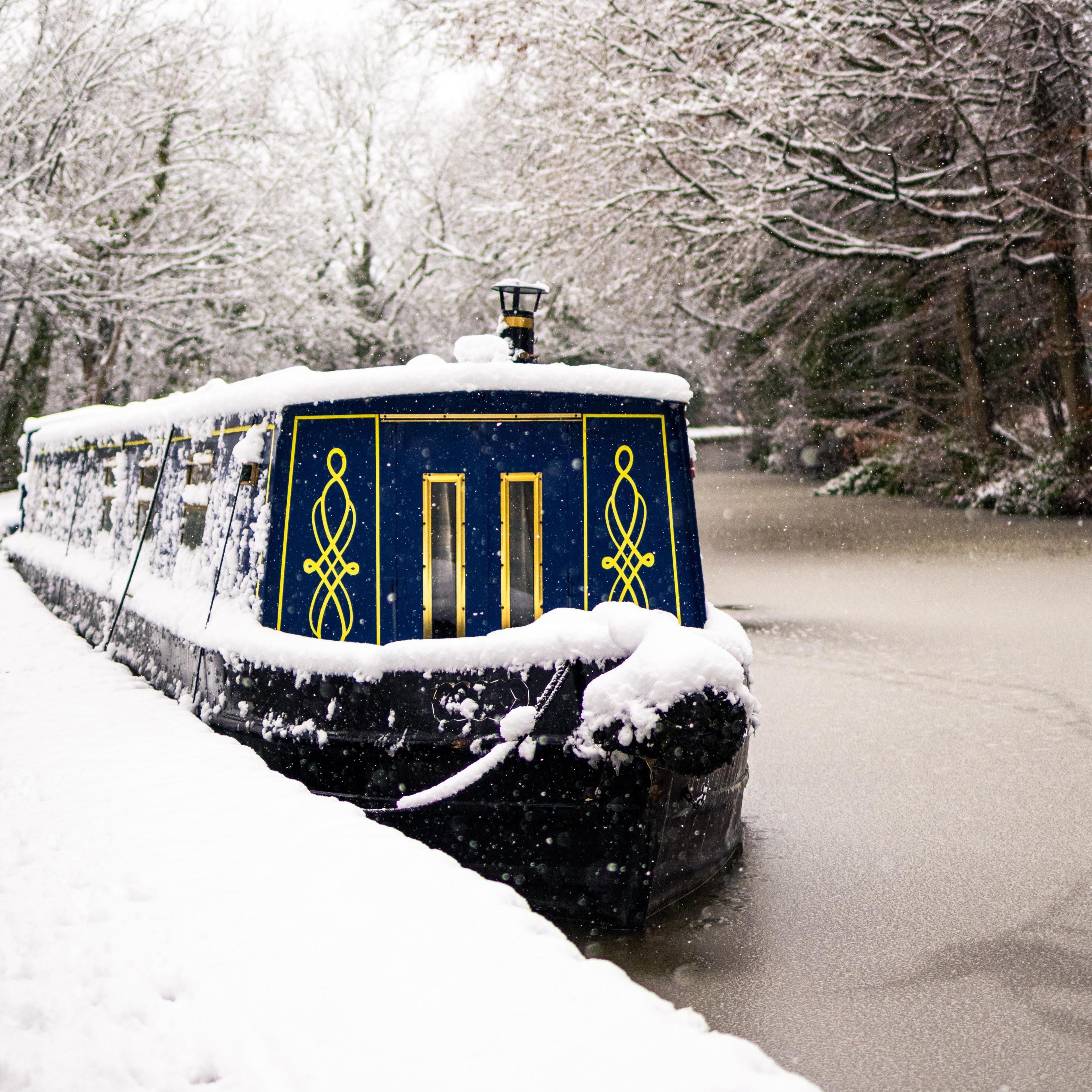 A snow-covered barge moored in a canal in Bingley, Bradford