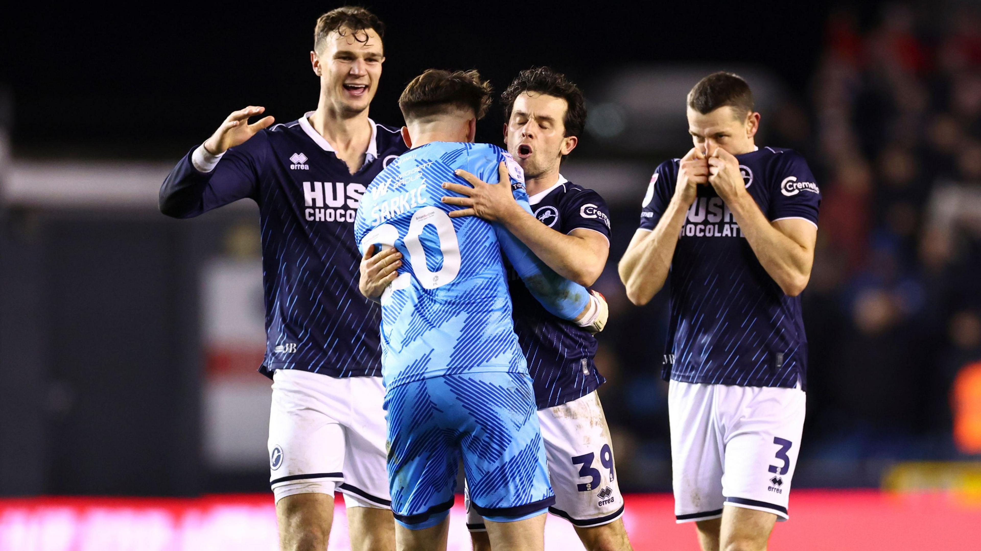 Sarkic is embraced by teammates Jake Cooper, left, George Honeyman, middle, and Murray Wallace