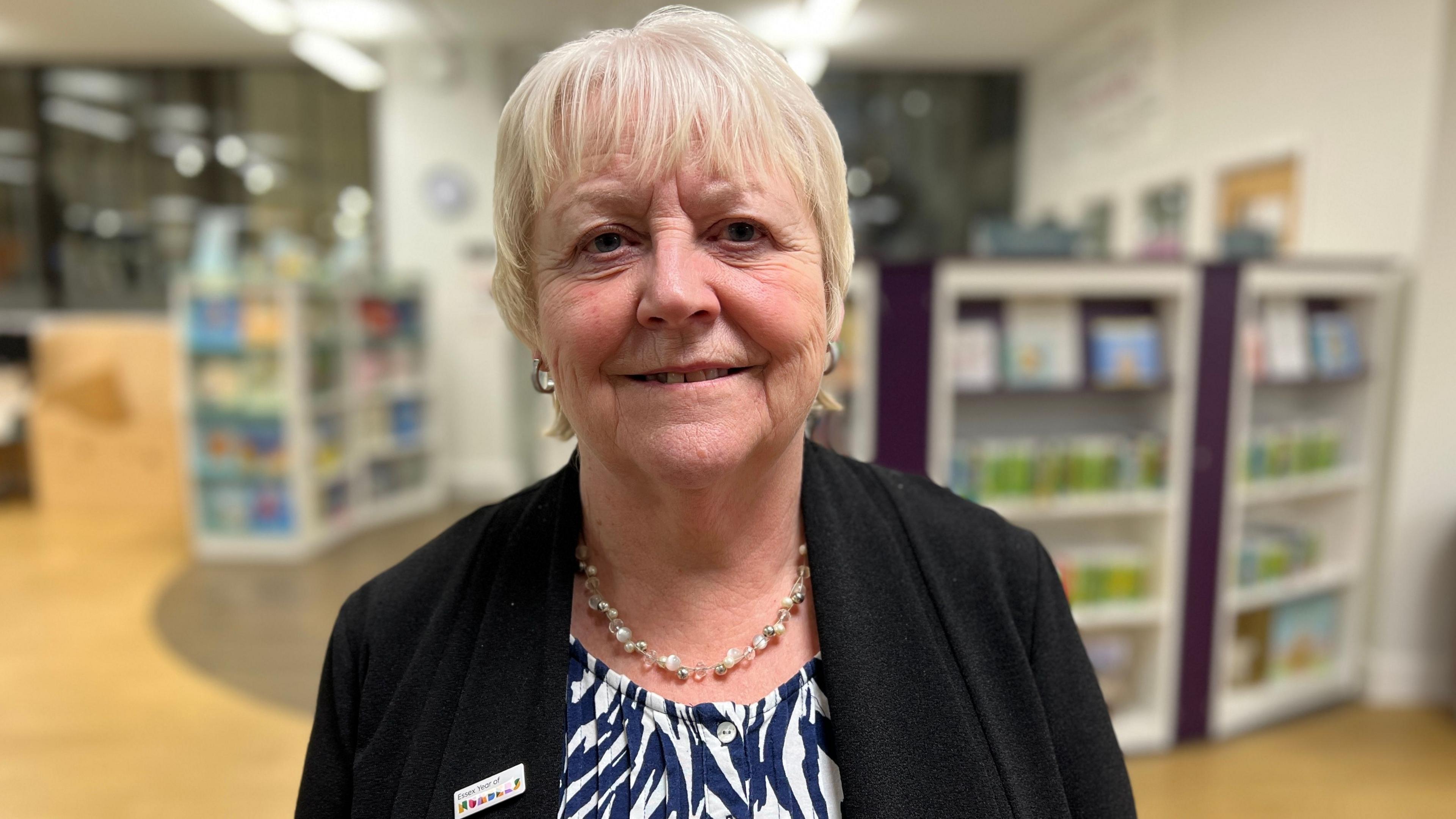 Councillor Beverley Egan smiling at the camera. She is a woman with blonder hair and wearing a blouse and a black cardigan. 