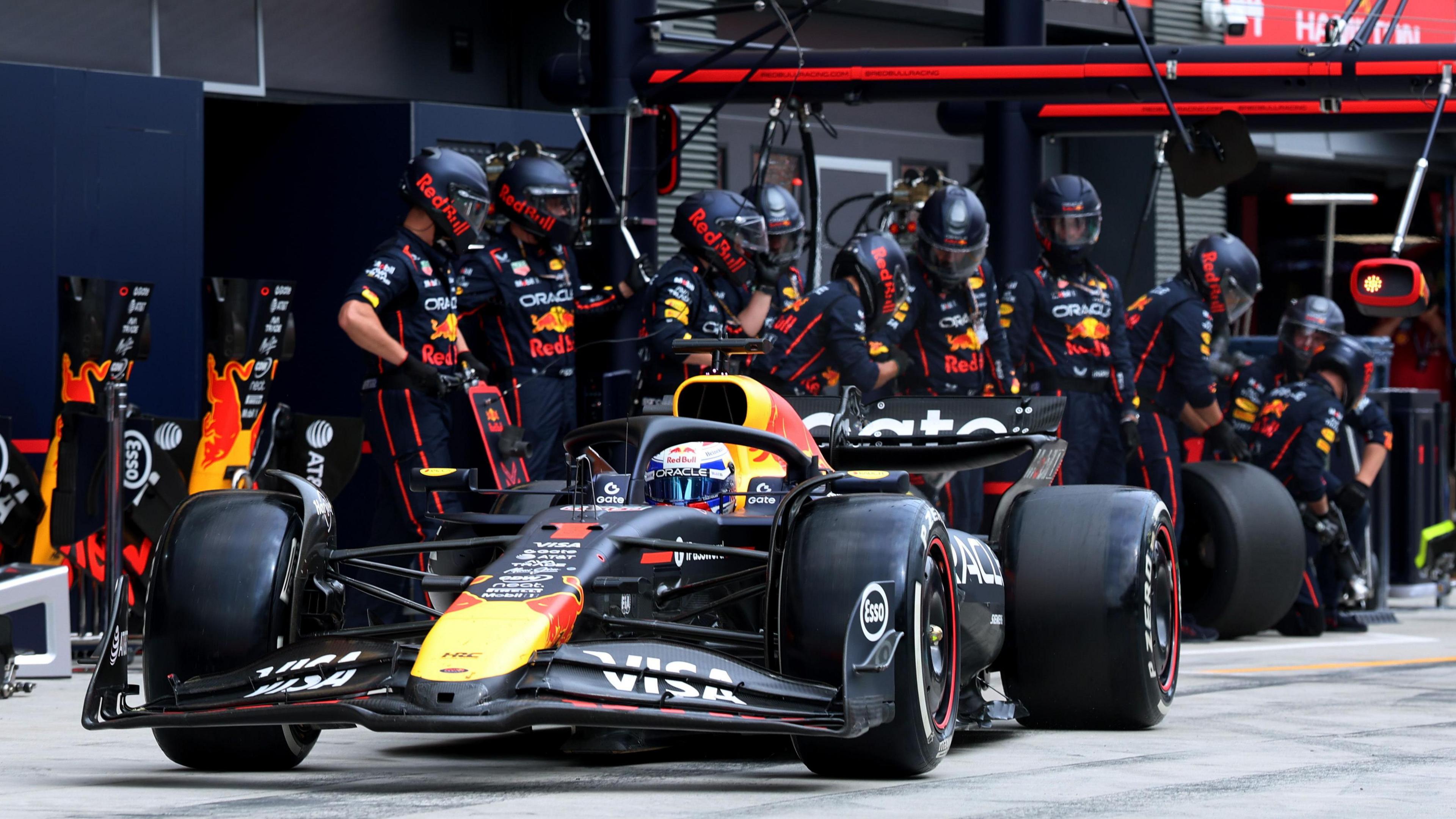 Max Verstappen in his Red Bull car with a team of Red Bull engineers behind the car at the recent Hungarian Grand Prix